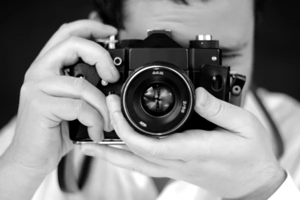 Fotograaf met camera in studio, zwart-wit foto — Stockfoto