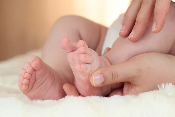 Neugeborene Babyfüße auf weiblichen Händen — Stockfoto