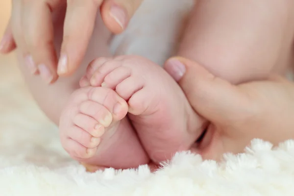 Les pieds d'un petit garçon dans les mains de sa mère — Photo