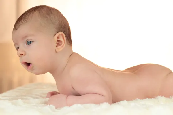 Lindo desnudo bebé chico se encuentra en su estómago — Foto de Stock