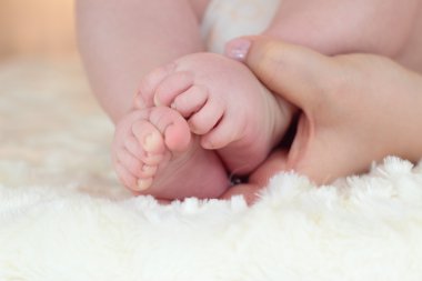 Yeni doğan bebeğin ayakları üzerinde eller