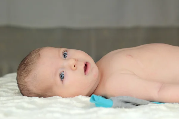 Carino piccolo bambino sdraiato sulla schiena e guardando la fotocamera — Foto Stock