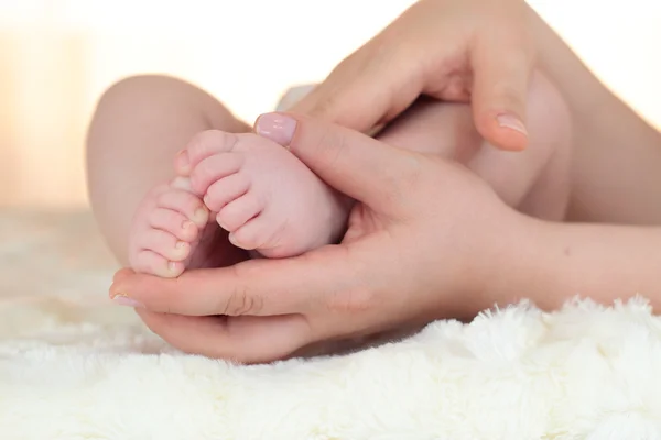 赤ちゃんの男の子の足の彼の母の手で開催されています。 — ストック写真