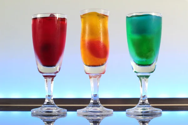 Närbild av en rad färgstarka cocktails vilar på baren med led belysning på en klubb — Stockfoto