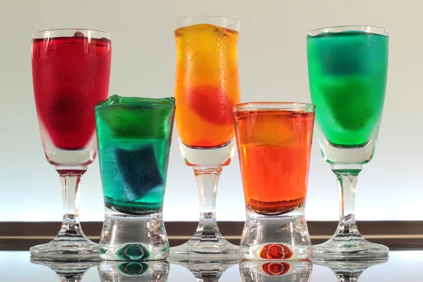 Närbild av en rad färgstarka cocktails vilar på baren med led belysning på en klubb — Stockfoto