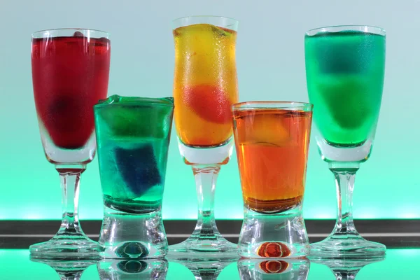 Primer plano de una línea de cócteles coloridos que descansan en el bar con iluminación led en un club — Foto de Stock