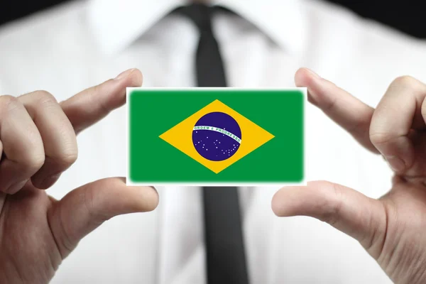 Geschäftsmann mit einer Visitenkarte mit brasilianischer Flagge — Stockfoto