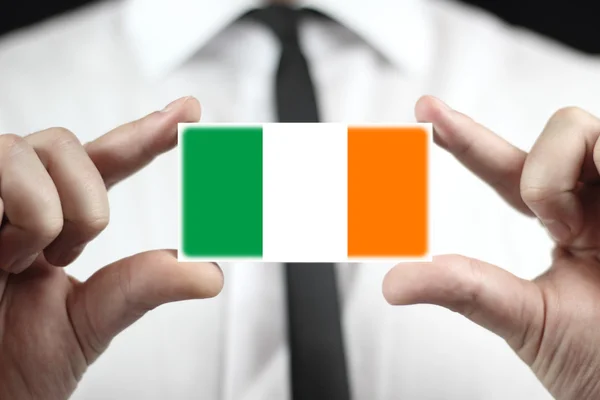 Empresario con una tarjeta de visita con bandera de Irlanda — Foto de Stock