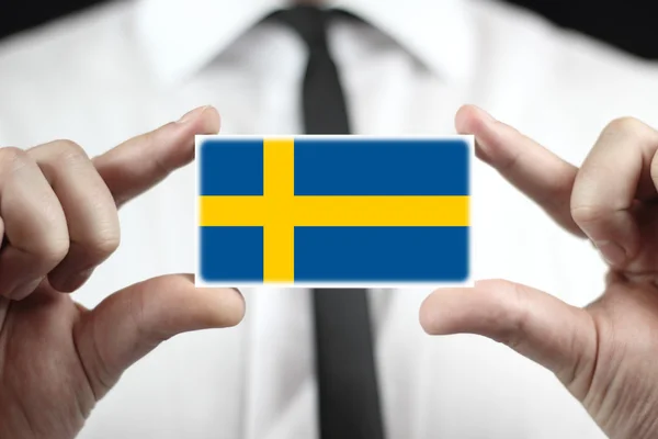 Geschäftsmann mit einer Visitenkarte mit schwedischer Flagge — Stockfoto