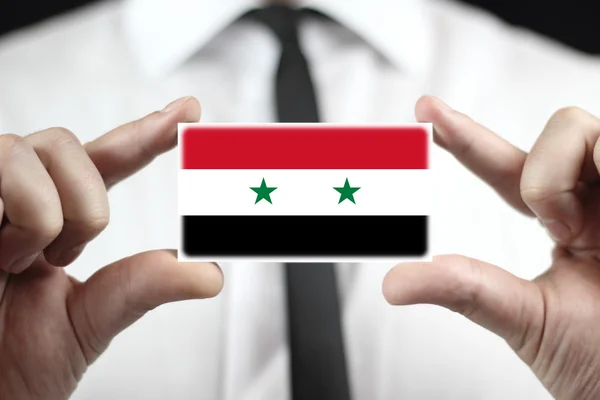Zakenman houden een visitekaartje met een vlag van Syrië — Stockfoto
