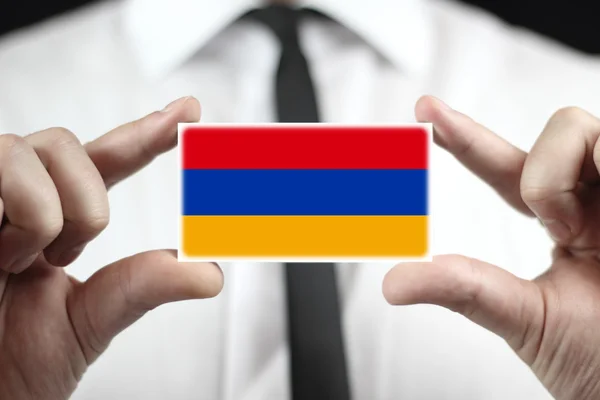 商人持有一张名片与亚美尼亚国旗 — 图库照片