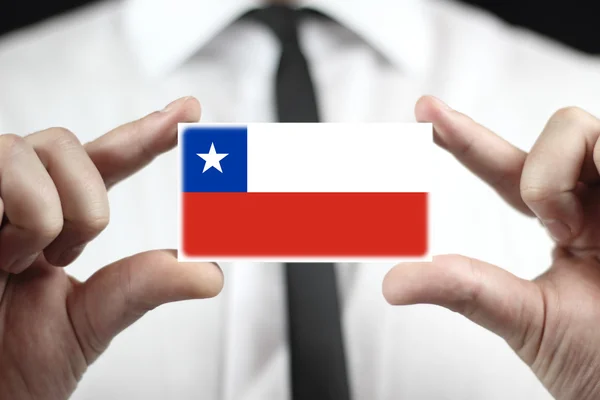 Бизнесмен, держащий визитную карточку с флагом Чили — стоковое фото