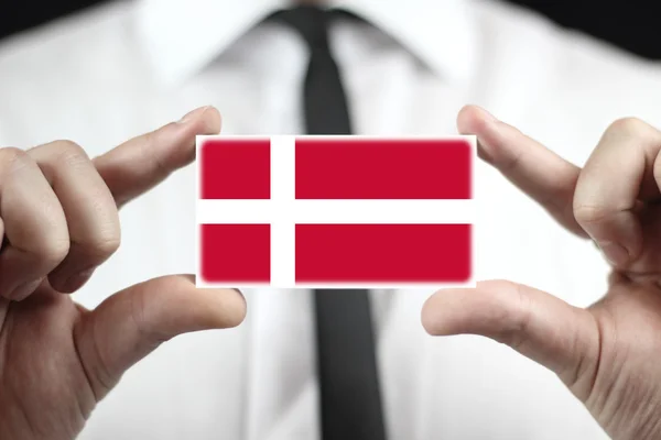 Danimarka bayrağı ile kartvizit tutan işadamı — Stok fotoğraf