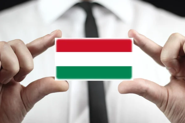 Uomo d'affari in possesso di un biglietto da visita con bandiera ungherese — Foto Stock