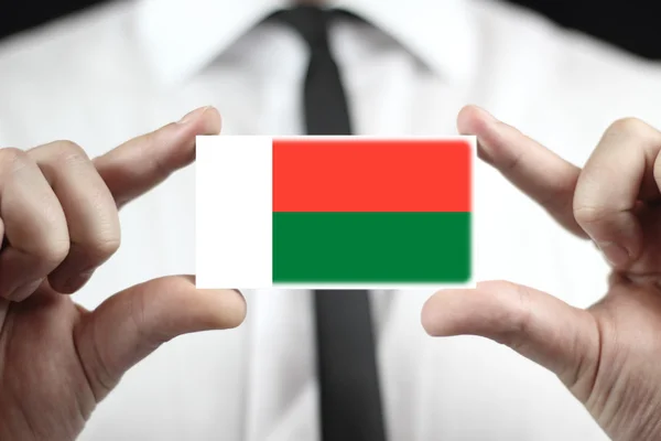 Homme d'affaires titulaire d'une carte de visite avec un drapeau malgache — Photo
