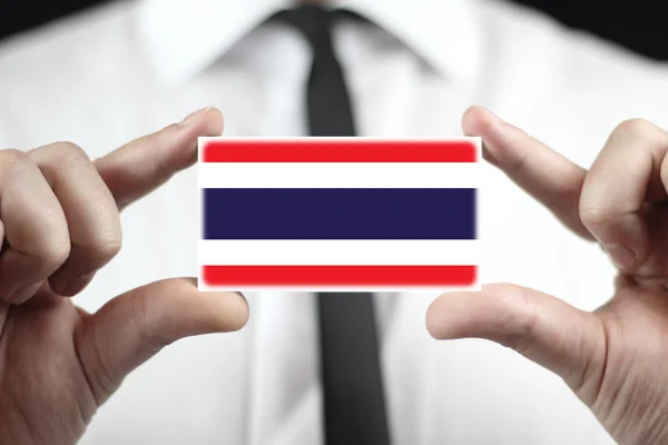 Kartvizit Tayland bayrağı ile tutan işadamı — Stok fotoğraf