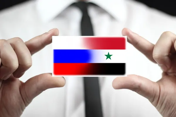 Empresario con tarjeta de visita con bandera de Rusia y Siria —  Fotos de Stock