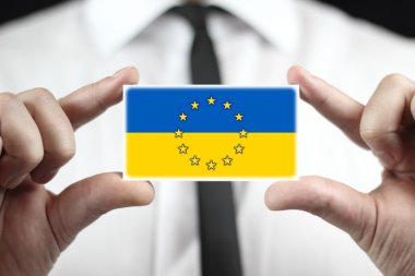 Kartvizit AB ve Ukrayna bayrağı ile tutan işadamı