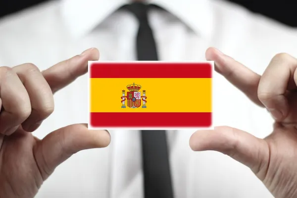 Podnikatel drží vizitku s příznakem Španělsko — Stock fotografie
