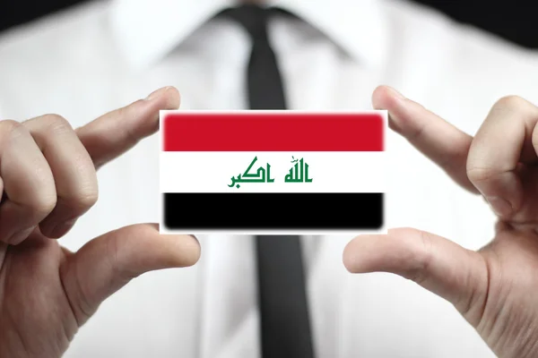 Empresario con una tarjeta de visita con bandera de Irak —  Fotos de Stock