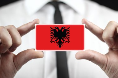 Kartvizit Arnavutluk bayrağı ile tutan işadamı