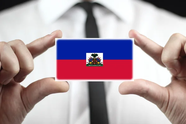Empresário segurando um cartão de visita com Bandeira do Haiti — Fotografia de Stock