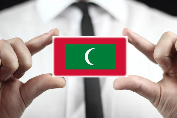 Podnikatel drží vizitku s Malediv vlajka — Stock fotografie