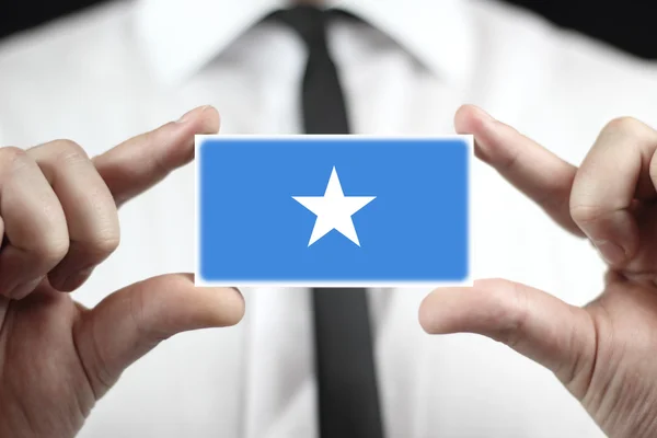 Businessman holding a business card with Somalia Flag — Stock Photo, Image