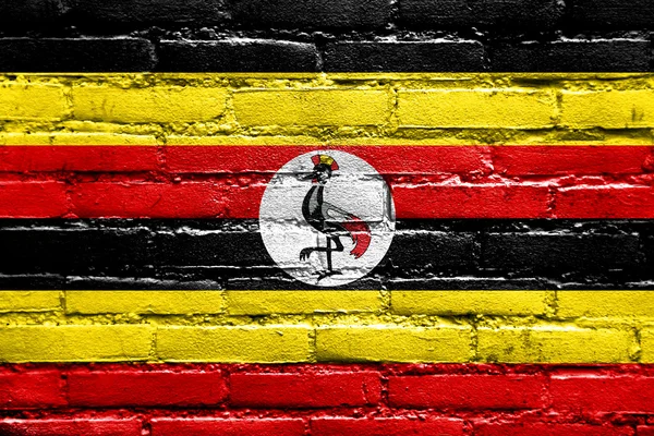 挂在砖墙上的乌干达国旗 — 图库照片
