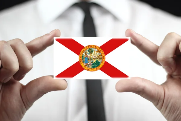 Businessman holding a business card with Florida Flag — Stock Photo, Image