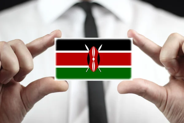 Businessman holding a business card with Kenya Flag — Stock Photo, Image