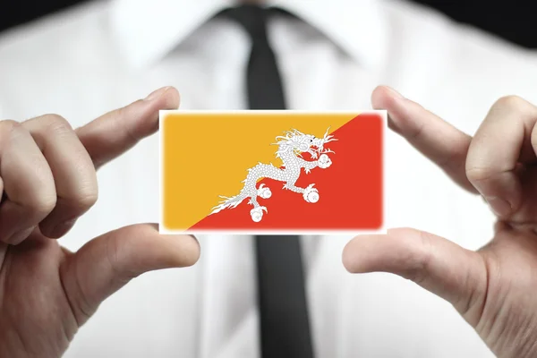 Geschäftsmann mit einer Visitenkarte mit Bhutan-Flagge — Stockfoto