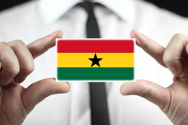 Empresario con una tarjeta de visita con la bandera de Ghana — Foto de Stock