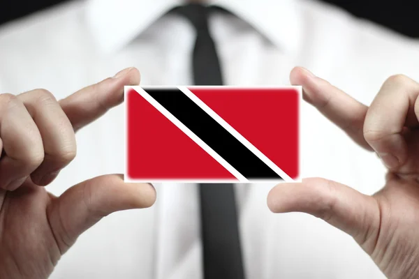 Empresário segurando um cartão de visita com Bandeira de Trinidad e Tobago — Fotografia de Stock