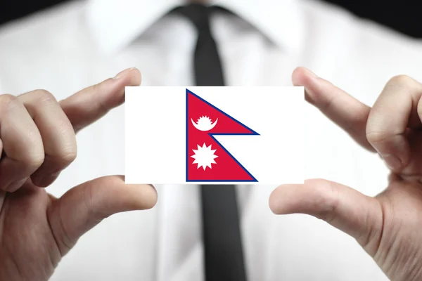 Businessman holding a business card with Nepal Flag — Stock Photo, Image