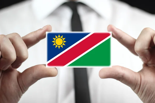 Businessman holding a business card with Namibia Flag — Stock Photo, Image