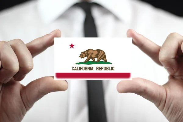 Zakenman houden een visitekaartje met vlag van Californië — Stockfoto