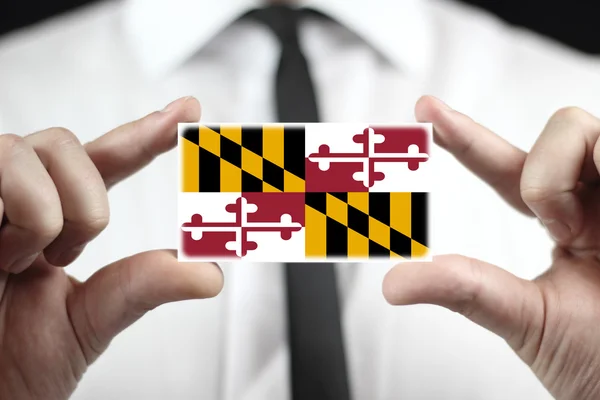 Empresário segurando um cartão de visita com Bandeira Estadual de Maryland — Fotografia de Stock