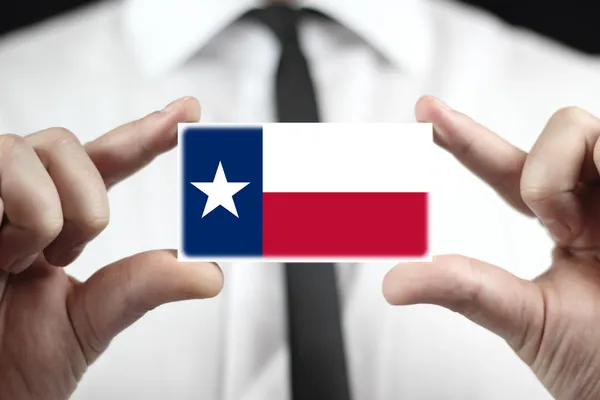Podnikatel drží vizitku s vlajkou státu texas — Stock fotografie
