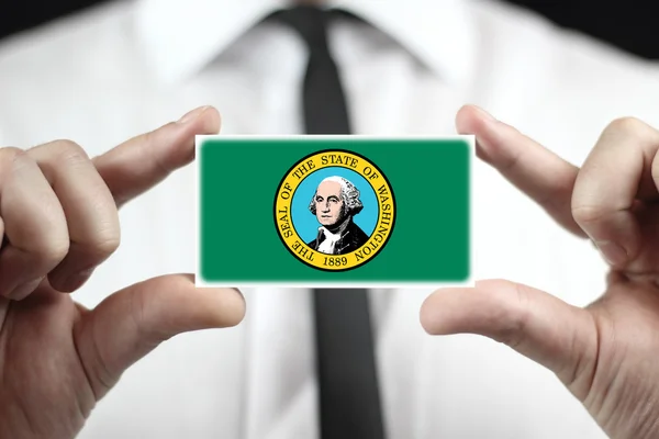 Uomo d'affari in possesso di un biglietto da visita con bandiera dello Stato di Washington — Foto Stock