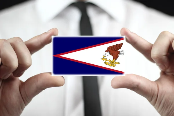 Biznesmen posiadania wizytówki z flaga samoa amerykańskie — Zdjęcie stockowe