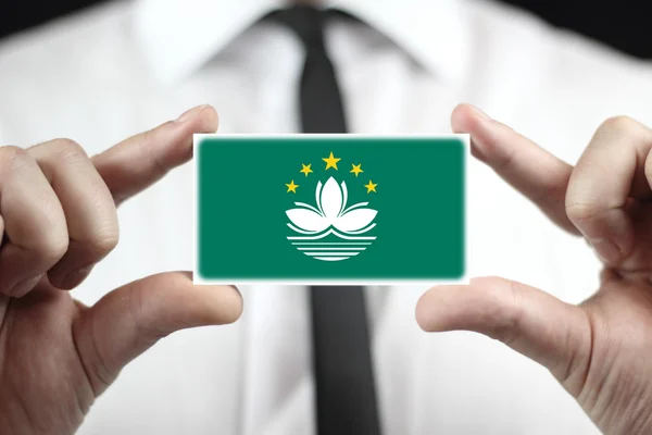 Businessman holding a business card with Macau Flag — Stock Photo, Image