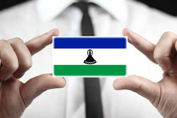 Empresario con tarjeta de visita con bandera de Lesotho — Foto de Stock