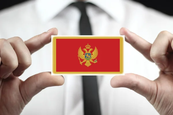 Empresário segurando um cartão de visita com Bandeira Montenegro — Fotografia de Stock