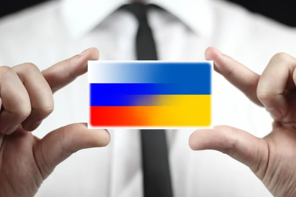 Empresario con tarjeta de visita con bandera de Ucrania y Rusia — Foto de Stock