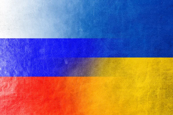 Bandera de Ucrania y Rusia pintada sobre textura de cuero — Foto de Stock