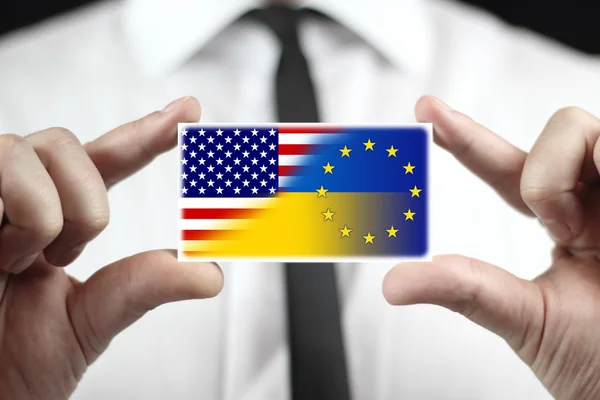 Businessman holding a business card with Ukraine, EU and USA Flag — Stock Photo, Image