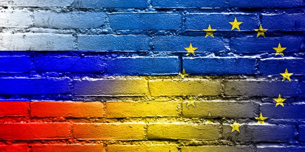 Ukrainische, eu und russische Flagge auf Ziegelwand gemalt — Stockfoto