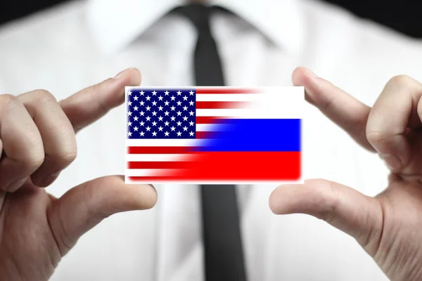 Empresario con tarjeta de visita con bandera de Estados Unidos y Rusia —  Fotos de Stock