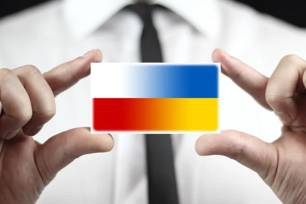 商人拿着名片与波兰和乌克兰的国旗 — 图库照片